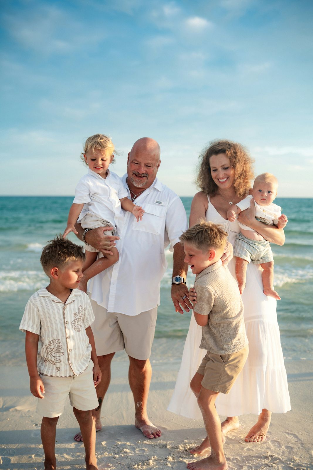 Grandparents holding their grandkids at the shoreline
