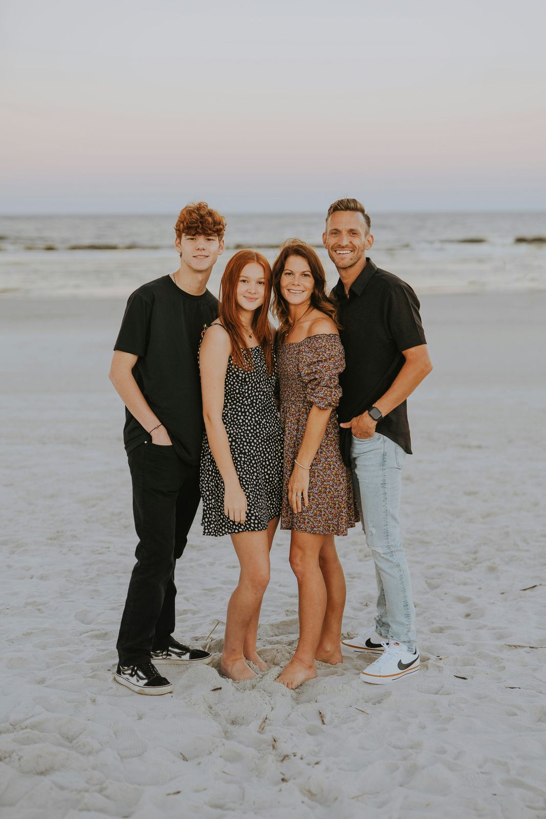 Parents with their teenage son and daughter on the sand